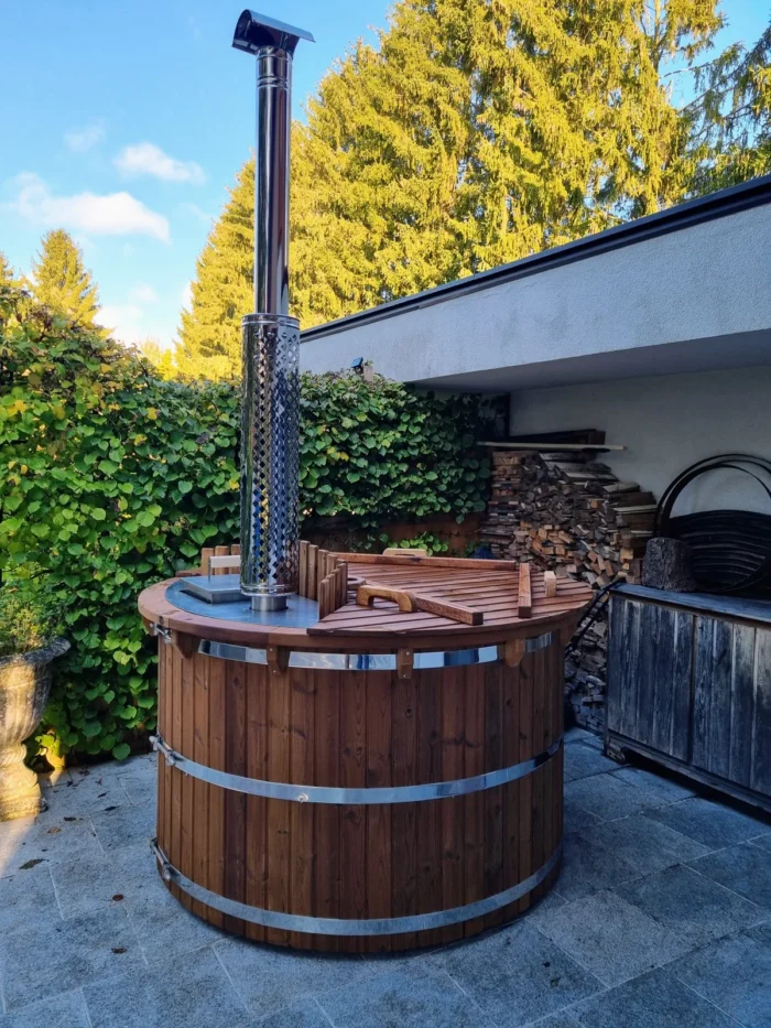 Vollholz-Badefass mit Metallbändern, Innenofen und Schornstein im Garten