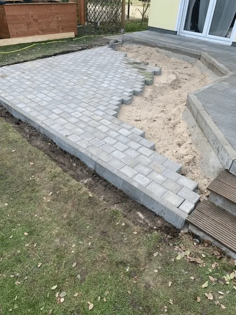 Untergrund 8 Neu verlegte Pflastersteine auf der vorbereiteten Badefass-Stellfläche neben der Haus-Terrasse