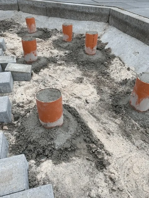 Untergrund 9 Vorbereitete Beton-Punktauflager in einer Kieszone für die Holzterrasse rund um ein Badefass