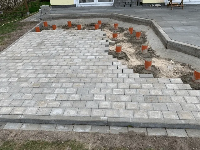 Untergrund 10 Gepflasterte Badefass-Fläche mit vorbereiteten Auflagerpunkten für eine anschließende Holzterrasse