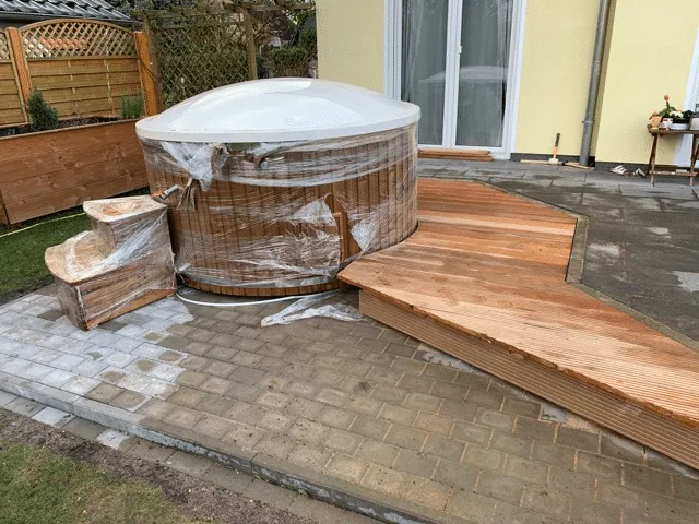 Untergrund 14 Rundes Badefass mit neuer Holzterrassen-Einfassung, passender Treppe und gepflastertem Wartungsbereich