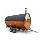 TimberIN Nordic Nomad™ Mobile Fasssauna – mobile Fasssauna mit Thermoholzkorpus, verglaster Panoramafront, Holzofenschornstein und zweiachsigem Straßenanhänger auf weißem Hintergrund.