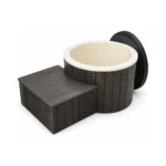 Eistonne 2 TimberIN Nordic Ice™ – rundes Kaltwasserbecken mit dunkler senkrechter Verkleidung, cremefarbenem isoliertem Einsatz, schwarzer aufgestellter Abdeckung und passendem Technikpodest auf weißem Hintergrund.