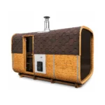 TimberIN Nordic Square Barrel™ – rechteckige Außensauna im Fassstil mit warmer Holzverkleidung, dunklem Schindeldach, verglaster Fronttür und Außenschornstein auf weißem Hintergrund.
