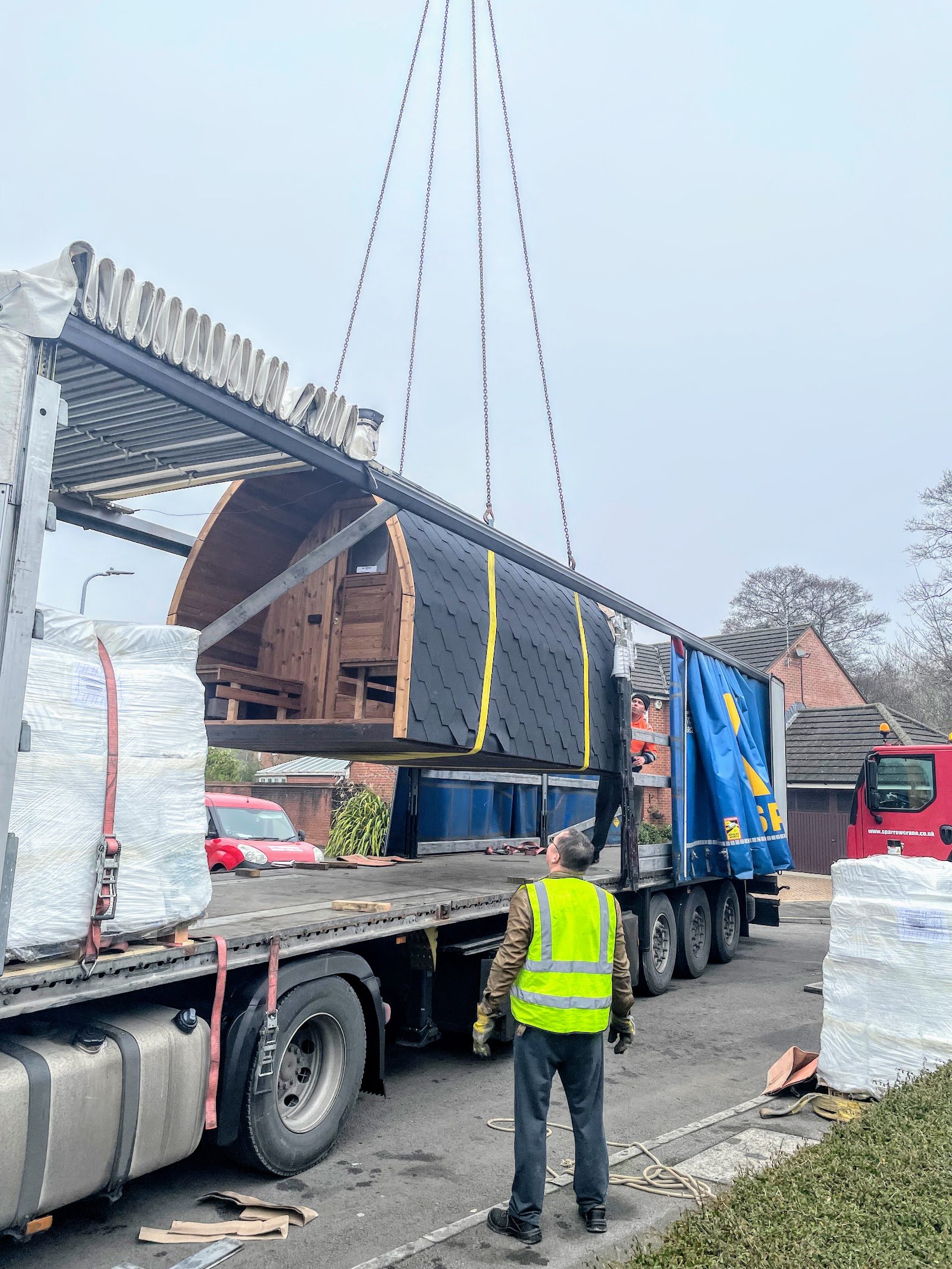 Fasssauna wird per Kran vom LKW gehoben