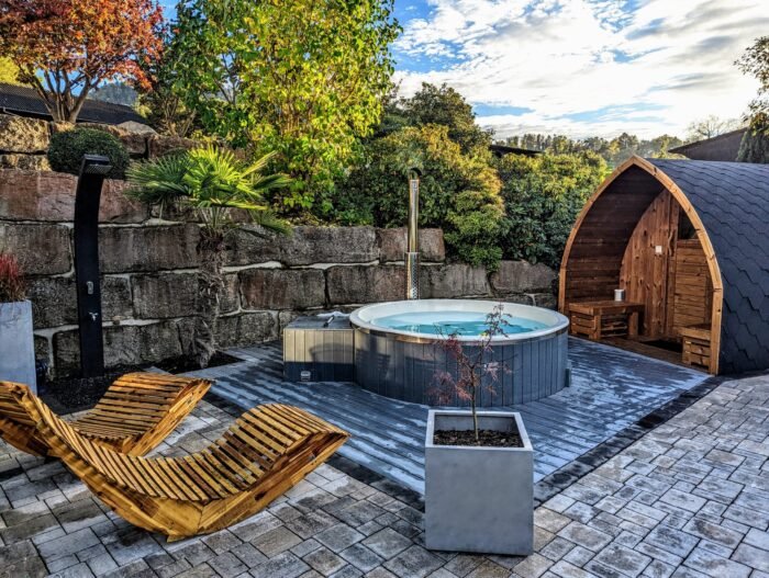 Badefass und separate Pod-Sauna nebeneinander auf einer Terrasse