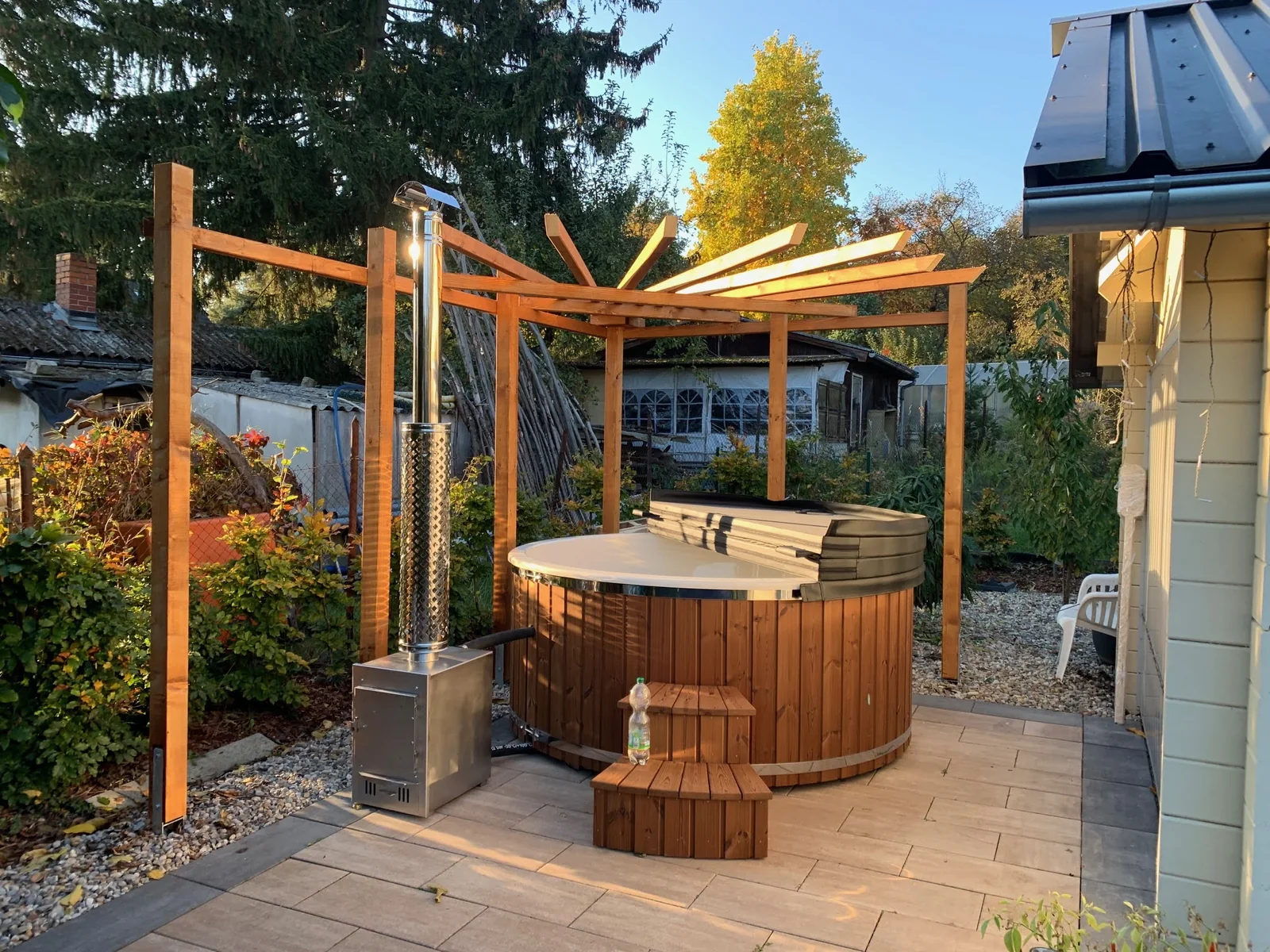 mit Holzofen 1 Holzverkleidetes Badefass mit Außenofen und Schornstein im Garten