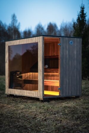 TimberIN Nordic Cube Außensauna mit Glasfront in der Dämmerung